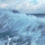 A man riding a wave on top of a body of water.